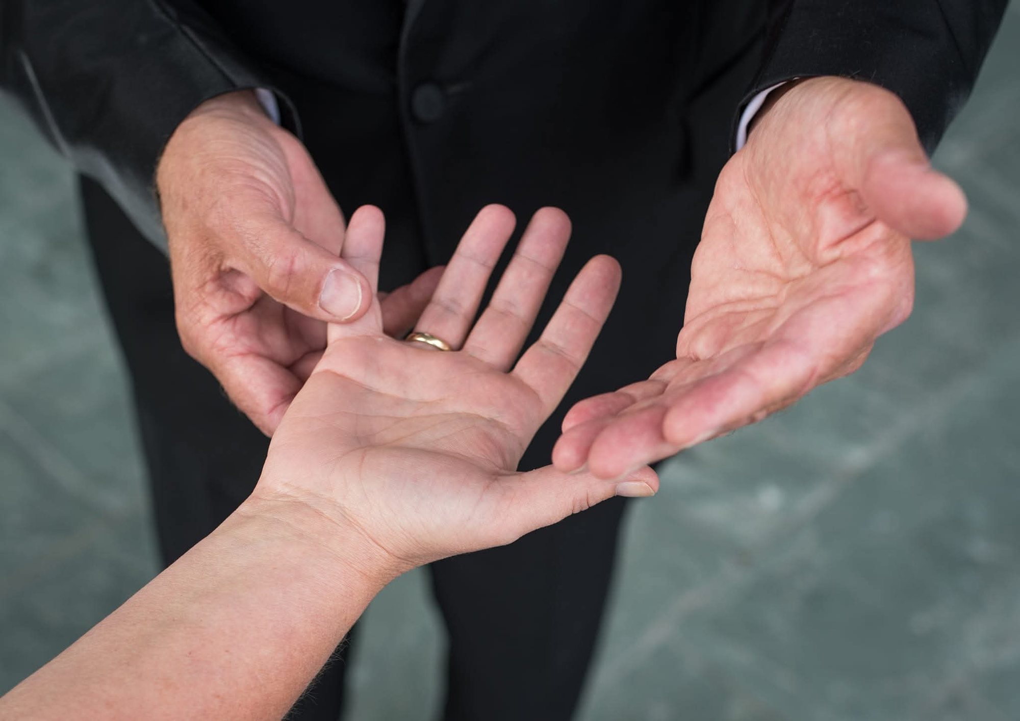 Close-up van de handen van Professor Drabb rond een open handpalm die hij leest