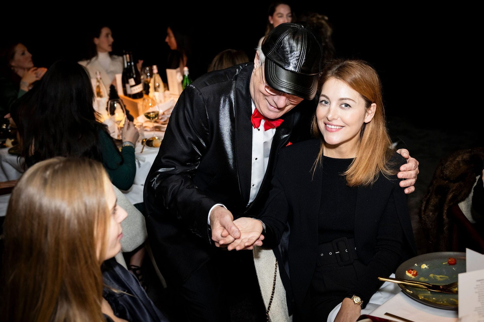 Tijdens een diner leest Professor Drabb, in smoking met rode strik, de hand van een lachende vrouw